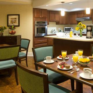 A modern kitchen and dining area with a breakfast table set with orange juice and coffee.