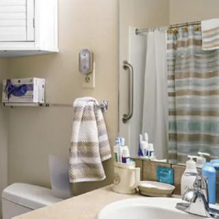 A clean bathroom with toiletries neatly arranged on the sink and a striped shower curtain.