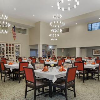 A spacious dining room with elegantly decorated tables and chandeliers.