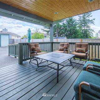 A cozy patio with comfortable seating and a table, perfect for outdoor relaxation.