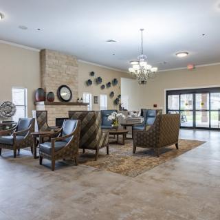 A spacious lobby with comfortable seating, a chandelier, and a fireplace.