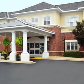 A welcoming entrance to a brick building with white columns.