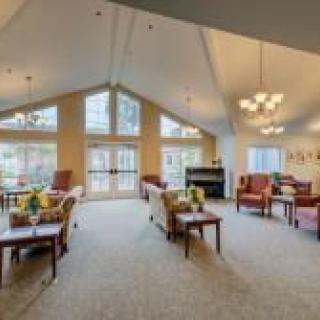 A spacious and well-lit living room with comfortable seating and large windows.