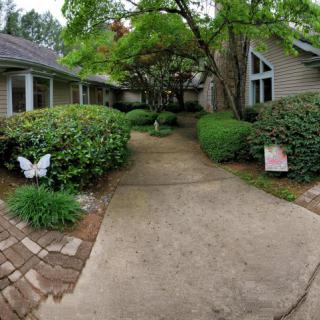 A serene walkway surrounded by lush greenery and decorative elements.