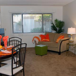 A cozy living room with a sofa, dining table, and decorative accents.
