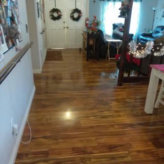 A cozy living room with hardwood floors and decorative wreaths on the doors.