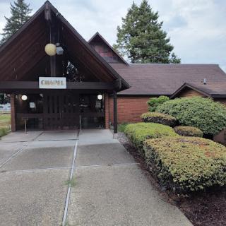 A welcoming entrance to a building surrounded by neatly trimmed bushes.