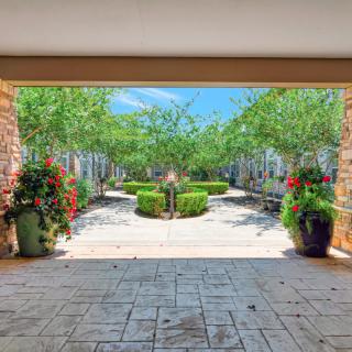 A beautifully landscaped garden pathway lined with vibrant potted plants.