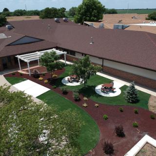 Aerial view of a beautifully landscaped outdoor space featuring seating areas, greenery, and pathways.
