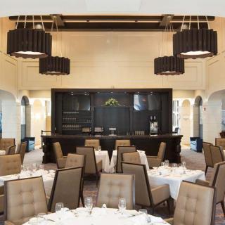 An elegantly designed restaurant interior with neatly arranged dining tables and sophisticated lighting fixtures.