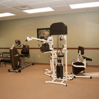 A gym room featuring various exercise equipment and workout machines.