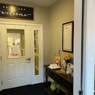 A warm and inviting entrance to an office space, featuring welcoming signage and a decorative table.