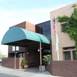 A building entrance with a green canopy and flagpole.