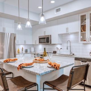 A modern kitchen with a spacious island and elegant pendant lights.