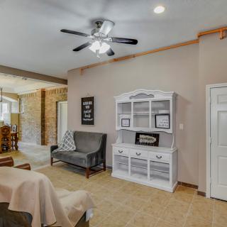 A cozy living room interior featuring a ceiling fan, white bookshelf, and comfortable seating area.