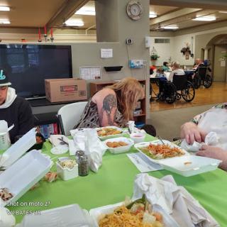 A group of people enjoying a meal together in a communal dining space.