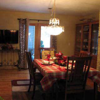A cozy dining room with a decorated table and a chandelier.