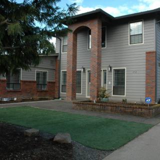 A suburban house with a brick facade and well-maintained lawn.