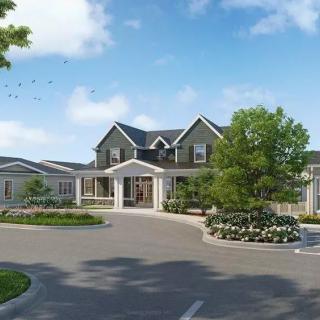 A large residential house with a driveway surrounded by trees and landscaping.