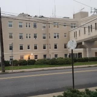 An exterior view of a hospital building on a cloudy day.