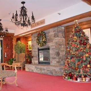 A cozy room adorned with festive Christmas decorations, including a decorated tree and a warm fireplace.