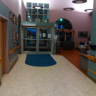 A view of the entrance lobby in a hospital, featuring a welcoming reception area and spacious waiting space.