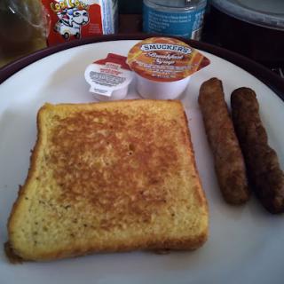 A delicious breakfast plate featuring golden french toast, sausage links, and a side of maple syrup.