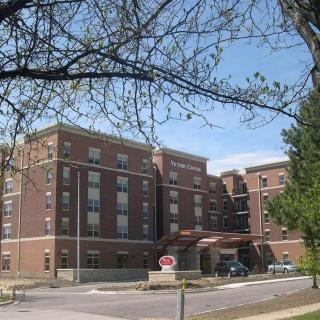 A brick building surrounded by trees on a clear day.