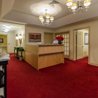 A warmly lit lobby area with a red carpet and reception desk.
