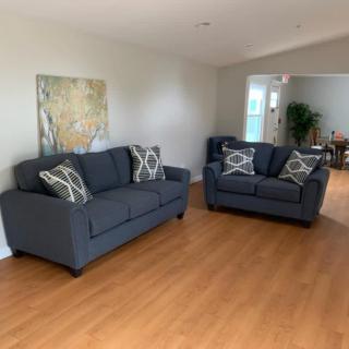 A cozy living room with two gray sofas and decorative pillows on a hardwood floor.