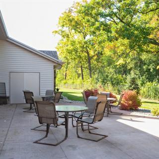 A sunny patio with outdoor furniture and a view of the garden.