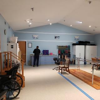 A spacious rehabilitation room equipped with various tools for physical therapy.