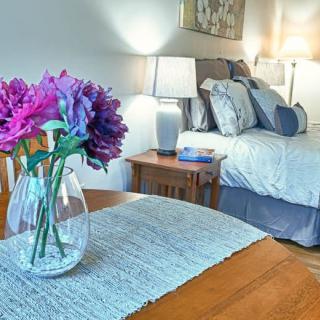 A cozy bedroom with a decorative vase of flowers on the table.