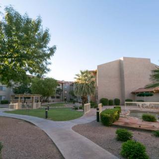 A scenic view of an apartment complex with manicured landscaping and pathways.