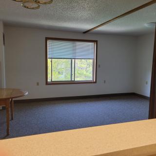 An empty room with a large window allowing natural light to enter.