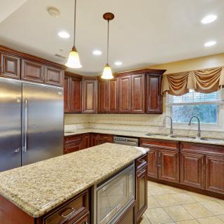 Modern kitchen with granite countertops and wood cabinets.