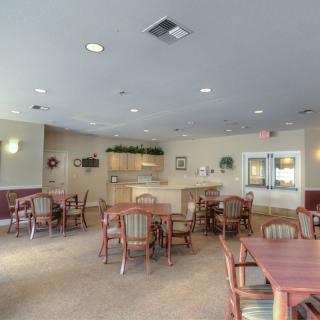 Spacious dining area with arranged tables and chairs, featuring bright lighting and decorative elements.