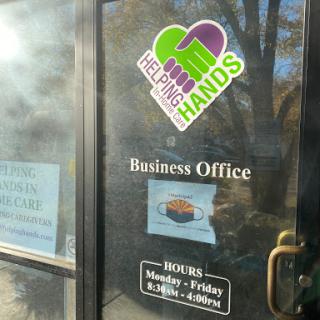 The entrance to a business office showcasing operational hours and branding.