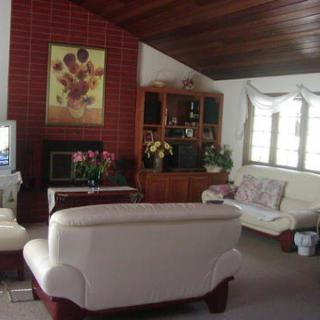 A cozy living room with white sofas, a brick fireplace, and various decorations.