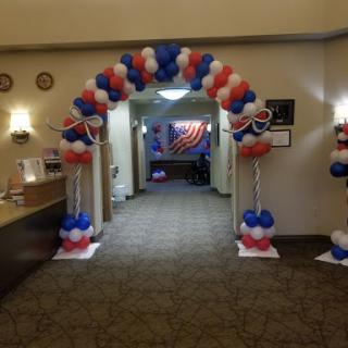 A festive entrance adorned with red, white, and blue balloons for a celebration.
