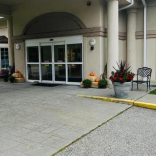 A building entrance decorated with pumpkins and plants, signifying an autumn theme.
