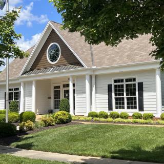 A charming suburban house with well-maintained landscaping and a circular window.
