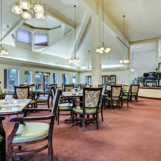 Spacious dining area with elegant chandeliers and well-arranged tables.