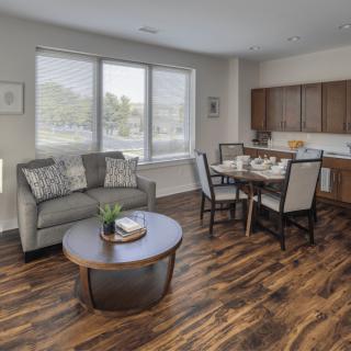 A modern open-concept living and dining area with wood flooring and contemporary furnishings.