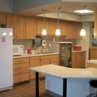 A modern kitchen with wooden cabinets and pendant lighting.