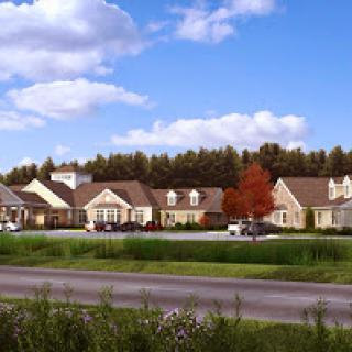 A peaceful suburban community featuring well-designed residential buildings and a clear blue sky.
