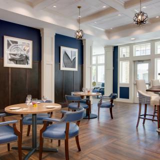 A modern restaurant interior with stylish tables and chairs, featuring elegant lighting and decor.