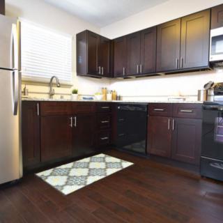 A modern kitchen with dark cabinets and stainless steel appliances.