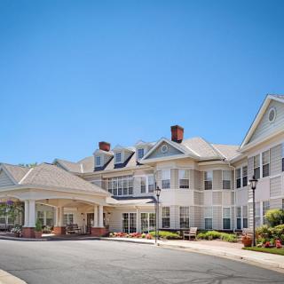 A large residential-style building with a covered entrance and expansive driveway.