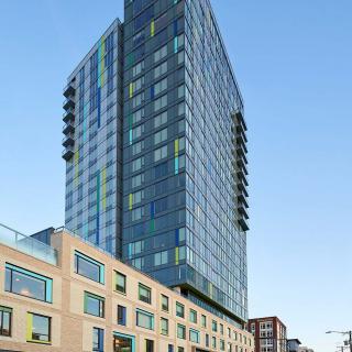 A modern skyscraper with a glass facade towering over the city.